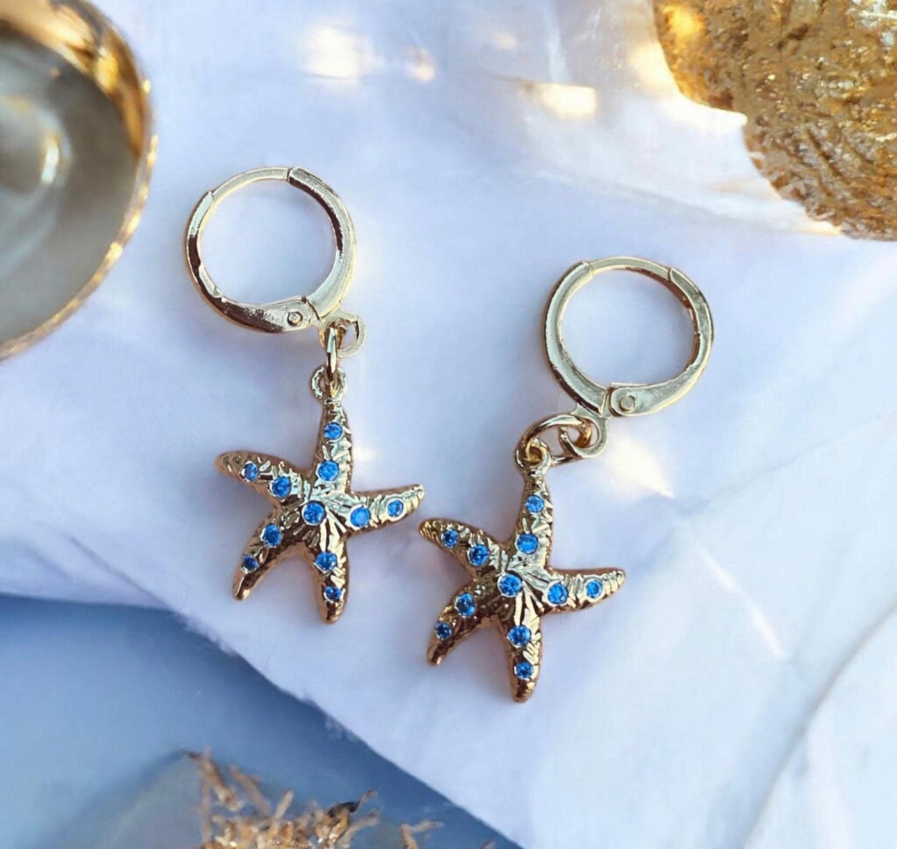 Les « Étoiles de mer » dorées à l’or fin 18 k et Zircons bleus.
